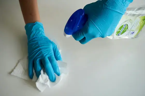 mavi eldivenli kişi beyaz tekstil tutuyor